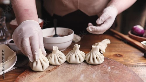 Georgian cuisine A female chef cooks khinkali in a restaurant. Traditional Caucasian food, the process of cooking khinkali.