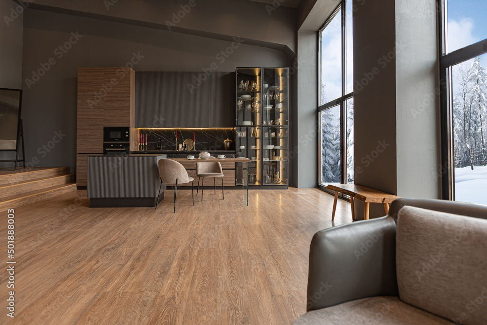 Fototapeta premium chic modern design of a dark expensive interior of a luxurious country house with huge panoramic windows and a magnificent view of the divine forest