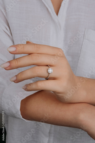 Close up of an elegant engagement diamond ring on female finger. love and wedding. Soft and selective focus.