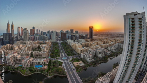 Sunrise over skyscrapers in Barsha Heights district and low rise buildings in Greens district aerial timelapse.