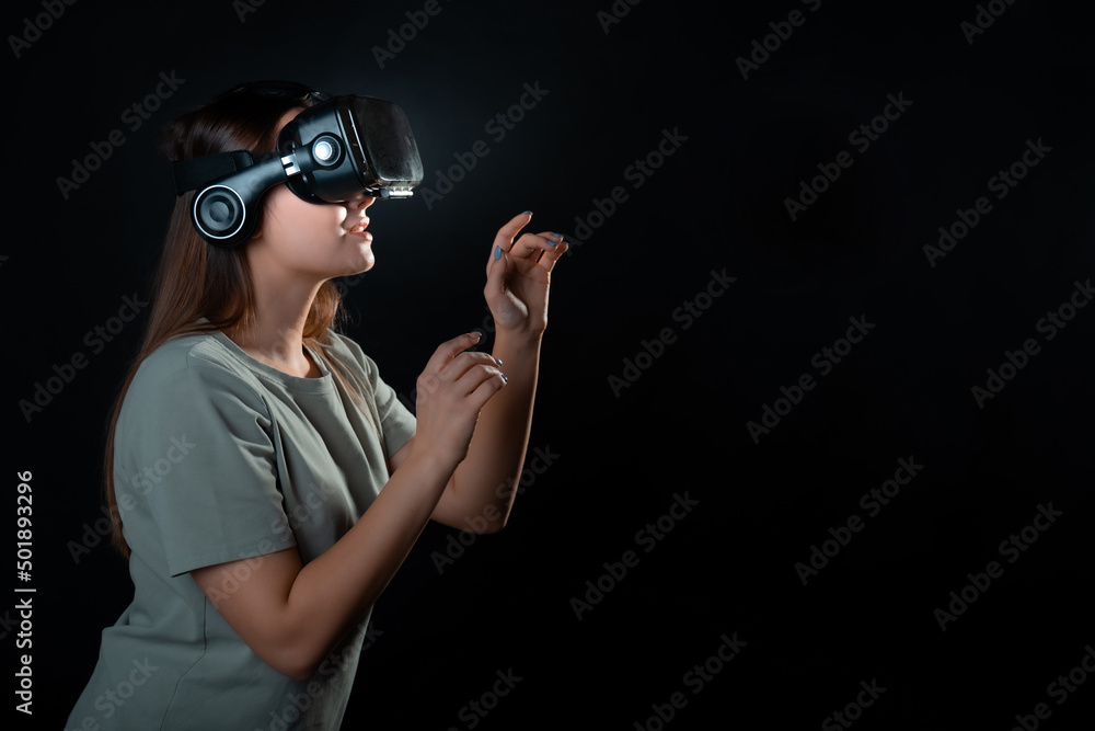 Virtual experience, a young woman using virtual reality glasses, playing a game or interacting with a metaverse, A girl in vr glasses touches a virtual object Virtual experience, a young woman using virtual reality glasses, playing a game or interacting with a metaverse, A girl in vr glasses touches a virtual object