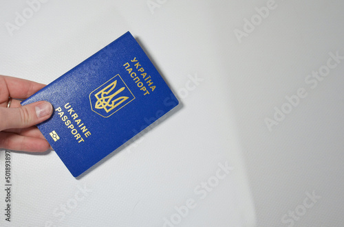 A girl holds a Ukrainian biometric passport in her hand, the concept of refugees