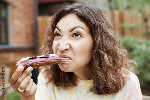 A girl sniffs a disgusting smell from a spoiled eclair cake photo