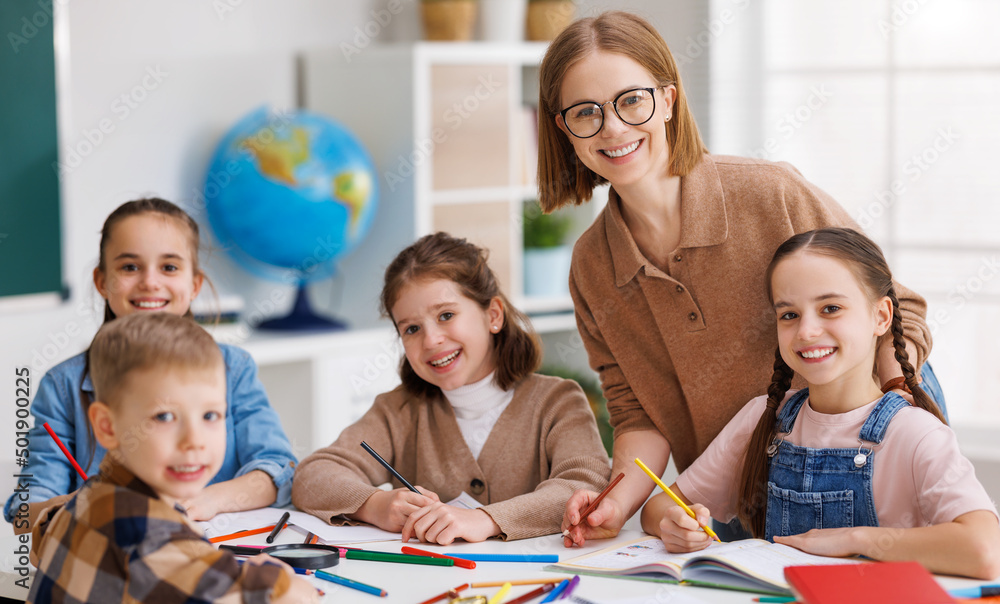 Fototapeta premium Teacher helping children with schoolwork