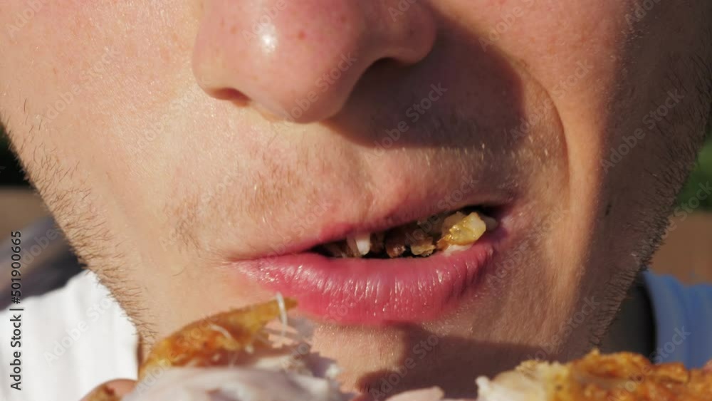 Young man eating fat fried chicken. Fast food concept. Close up. Guy enjoys junk street food from a restaurant Young man eating fat fried chicken. Fast food concept. Close up. Guy enjoys junk street food from a restaurant