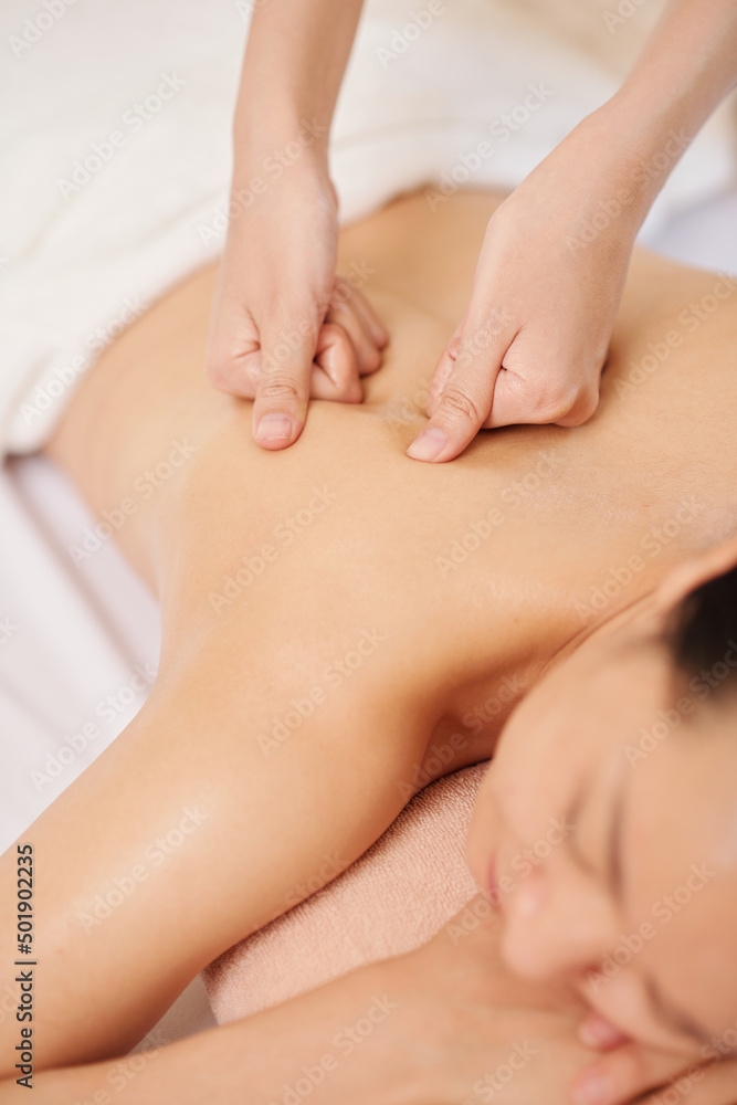 Hands massaging upper back of young female client Hands massaging upper back of young female client