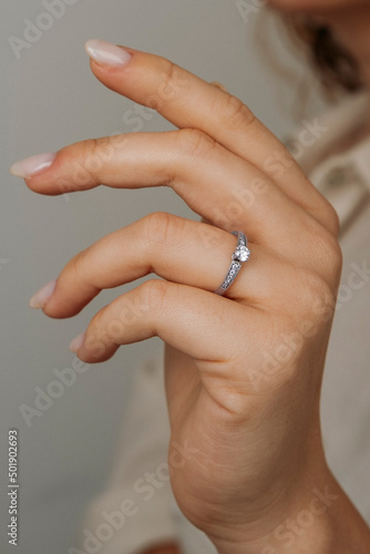 Close-up of elegant diamond ring on female finger. Love and wedding concept.Soft and selective focus.
