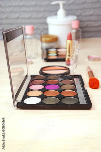 Cosmetics for professional makeup at home. Palettes of shadows, lipstick, cream and more. Selective focus.