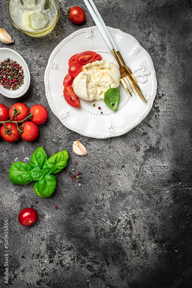 fresh soft white burrata cheese ball made from mozzarella and cream from Apulia, Italian Mediterranean cuisine, vertical image. top view. place for text fresh soft white burrata cheese ball made from mozzarella and cream from Apulia, Italian Mediterranean cuisine, vertical image. top view. place for text