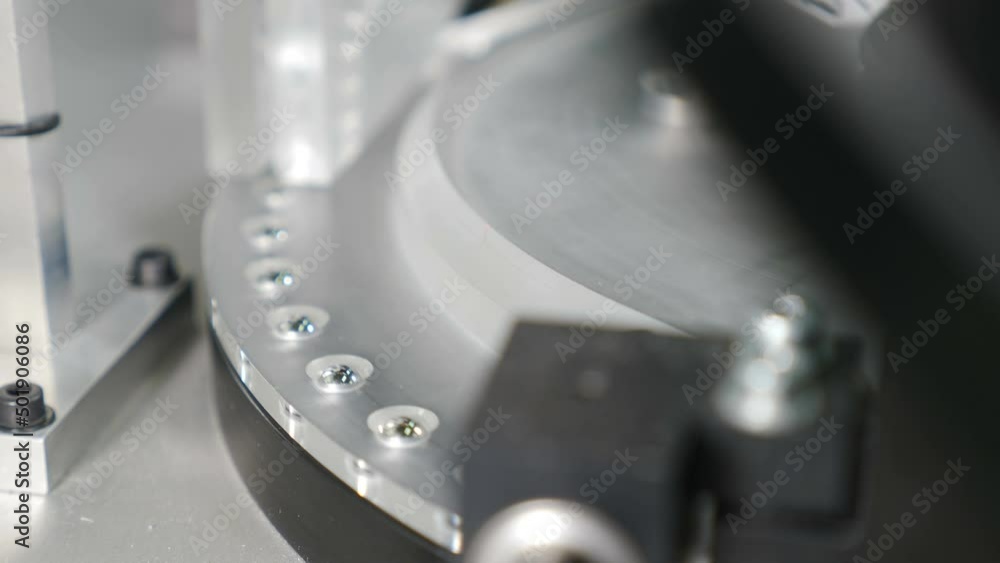 Industrial and machinery concept. Moving small metal balls for bearings on conveyor. Bearing assembling. Technological part of bearing production. Close up. Modern size distributing equipment 4 k Industrial and machinery concept. Moving small metal balls for bearings on conveyor. Bearing assembling. Technological part of bearing production. Close up. Modern size distributing equipment 4 k