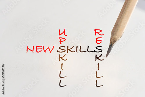New skills, reskill and upskill written on white paper with pencil. Future of work concept and success idea photo