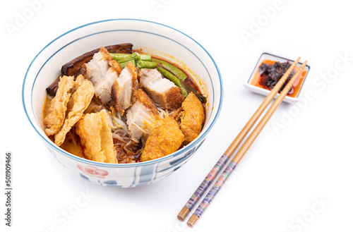 Curry mee or curry laksa is noodle served in curry broth made of cocunut milk, accompanied with roast pork, bean curd, vegetables. photo