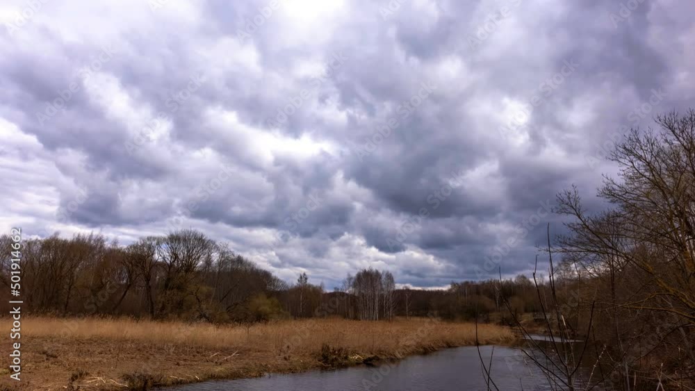 in spring, gray ball clouds move over the forest and the river turns white in spring, gray ball clouds move over the forest and the river turns white