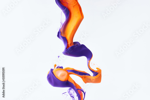 Paints splash curves in water on white. Acrylic orange and purple paint drop background. Abstract inks swirl texture