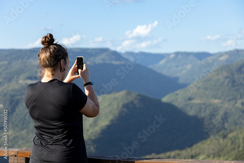 Female tourist taking photos at Parada da Torre Viewpoint, Cai River Valley, Nova Petropolis, Rio Grande do Sul highlands, Brazil