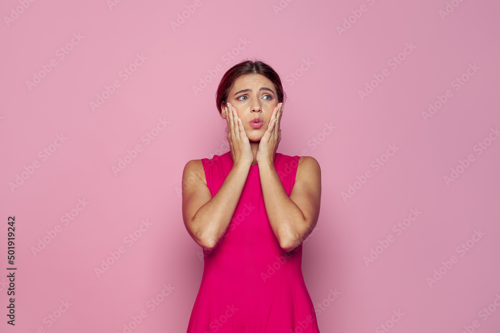 Portrait of shocked confused woman on pink background with copy space Portrait of shocked confused woman on pink background with copy space