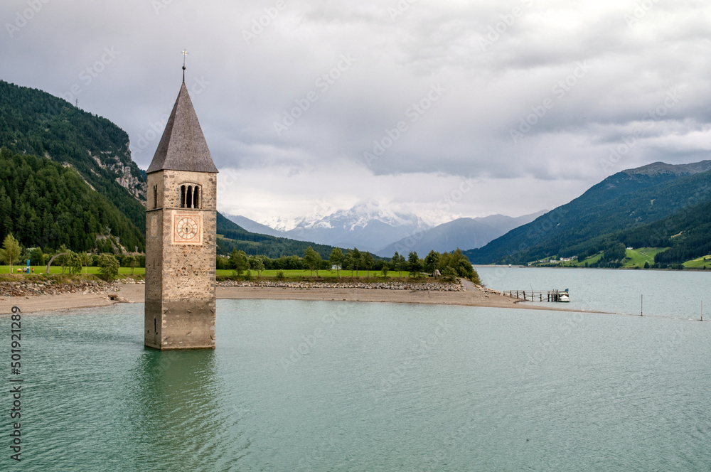 The tower of a flooded church in the middle of Lake Reschensee in the mountains between Austria, Italy and Switzerland