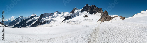 Glacier covered with a layer of snow in summer in Switzerland. High rocky mountains, a path in the snow for alpine hiking. © Jan
