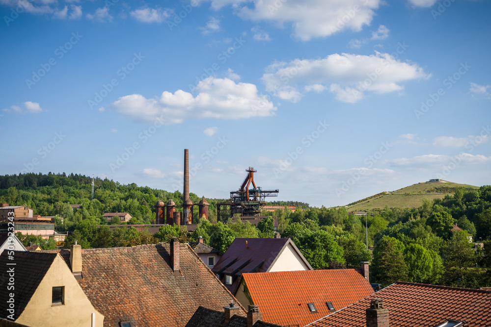 view over house rooftops decommissioned steel mill and slag mountain in sulzbach-rosenberg