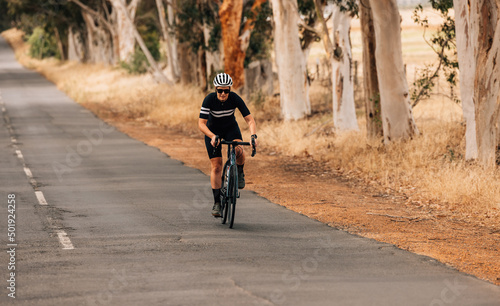 Athletic woman taking a intense bicycle ride on the empty countryside road