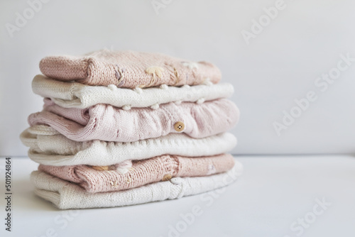 Stack of knitted clothes. Baby clothes. Needlework, hobby, knitting, handwork.