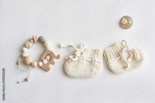 Baby accessories, booties, socks, wooden teether, pacifier, toy. Gift for child.