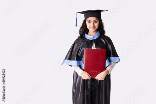 University graduate wearing academic regalia with red diploma. Background with copy space. photo