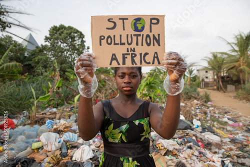 An African girl protests with a sign that reads 