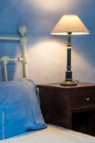 Detalle de cama y mesita de noche con lampara  photo