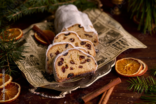 Christmas stollen on wooden background. Traditional christmas german dessert cut into pieces. Cake with nuts, raisins with marzipan and dried fruit on cutting board. baking for xmas