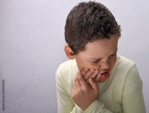 boy with toothache in pain on grey background stock photo