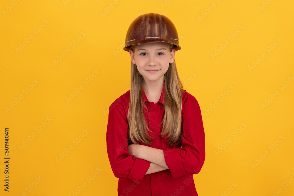 confident teen child in builder helmet on yellow background confident teen child in builder helmet on yellow background