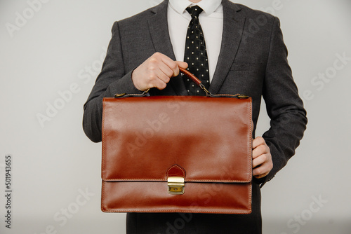 Close-up of businessman with briefcase in hand isolated on white background photo
