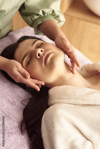 health and beauty, resort and relaxation concept - young woman in spa salon getting massage