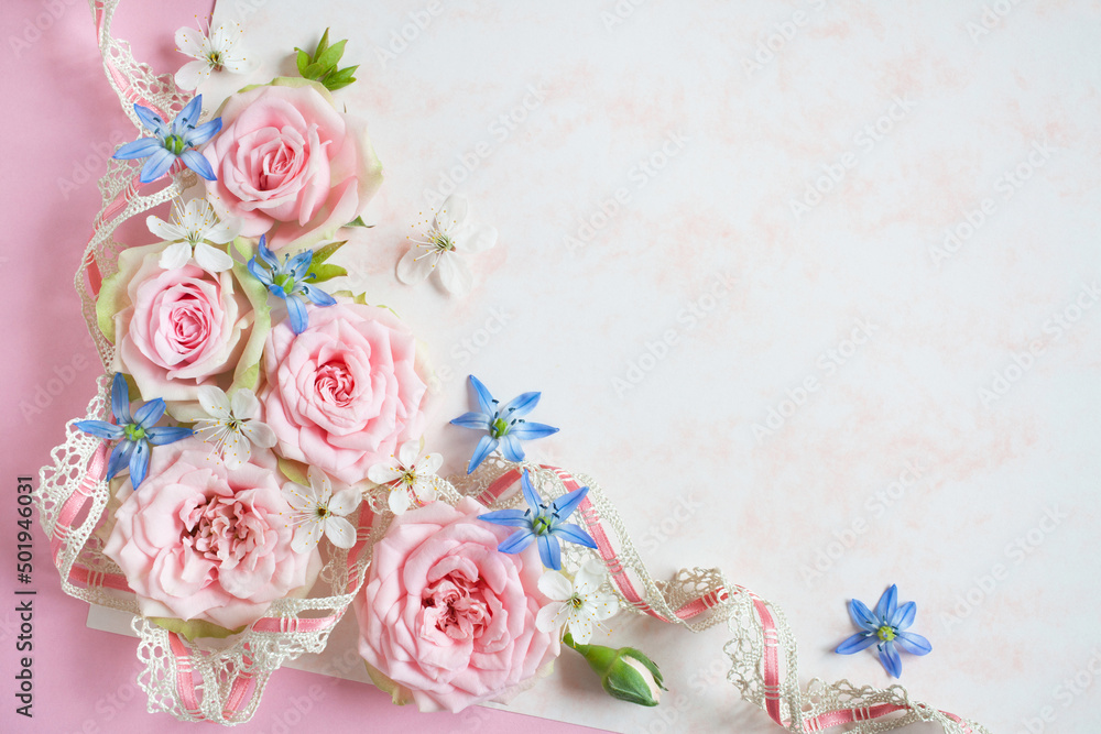 White-pink paper background, pink roses, cherry plum flowers, scilla and lace ribbon, space for text congratulation, invitation. Greeting card for wedding, holiday Mother's Day, birthday.