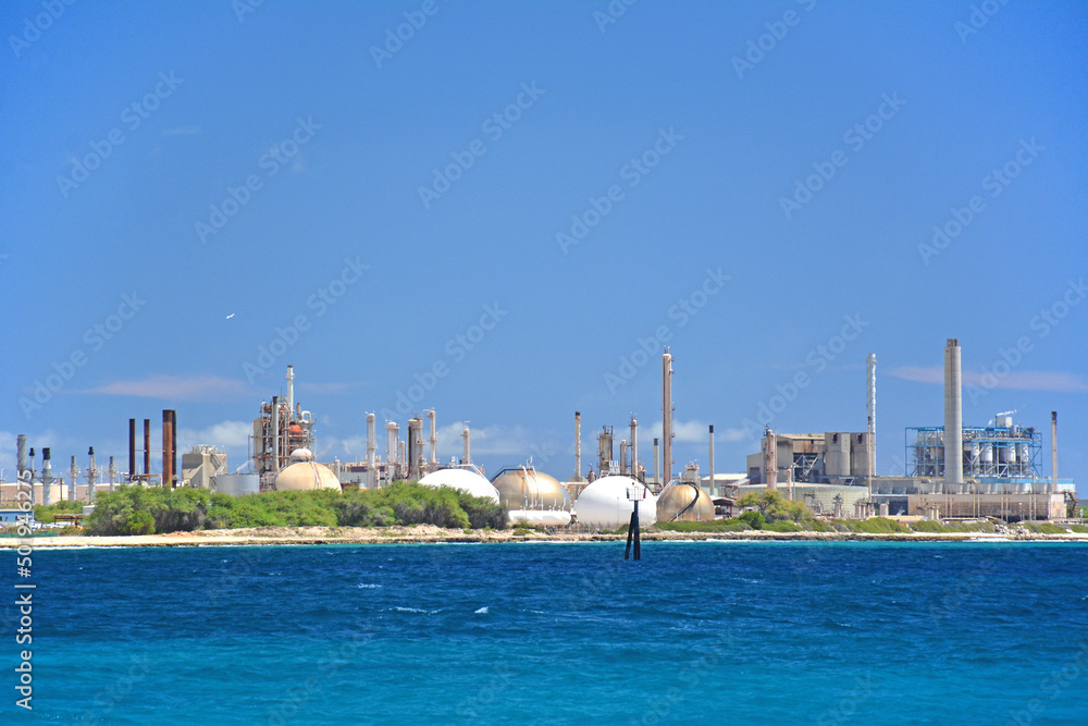 Fossil fuel energy plant producing electricity directly on the beach near a port in paradise