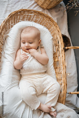 baby lies in a wicker basket eco style cocoon