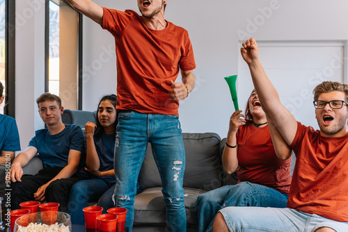 Fotografia friends jumping for joy after their team's victory, watching football match on TV