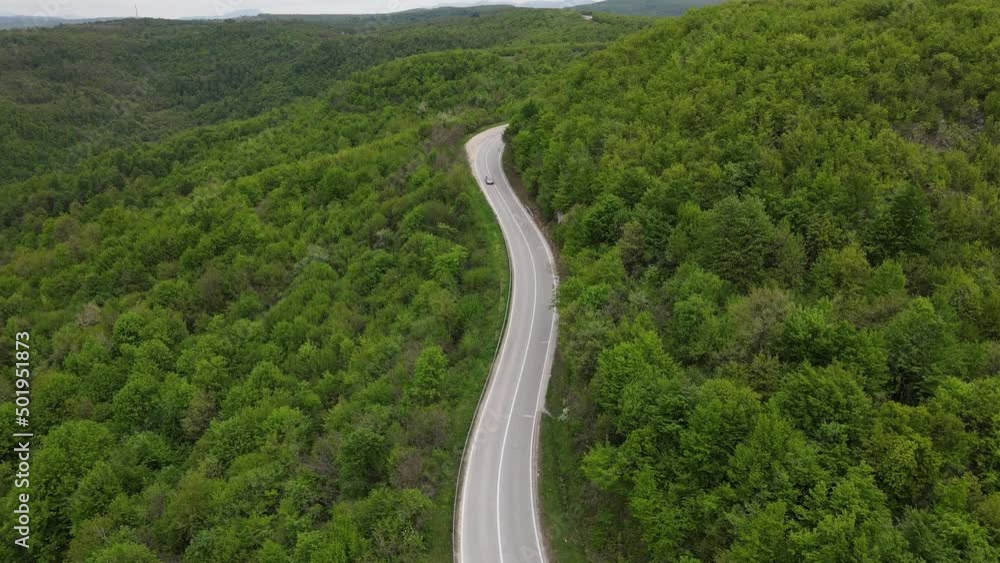 Top view on the road with cars travel and tourism transportation concept in spring day in trough the forest and trees aerial view from drone on Tresibaba - near Knjazevac Serbia Top view on the road with cars travel and tourism transportation concept in spring day in trough the forest and trees aerial view from drone on Tresibaba - near Knjazevac Serbia