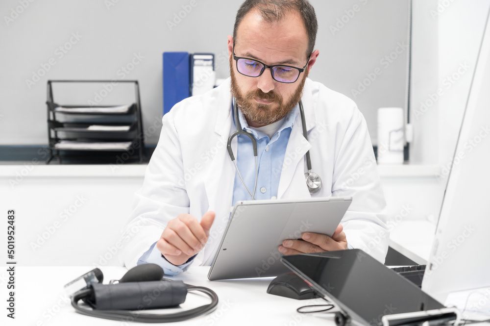 Doctor using his tablet computer at work. High quality photo Doctor using his tablet computer at work. High quality photo