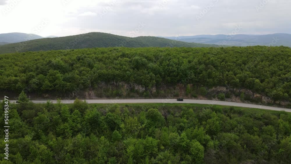 Top view on the road with cars travel and tourism transportation concept in spring day in trough the forest and trees aerial view from drone on Tresibaba - near Knjazevac Serbia Top view on the road with cars travel and tourism transportation concept in spring day in trough the forest and trees aerial view from drone on Tresibaba - near Knjazevac Serbia