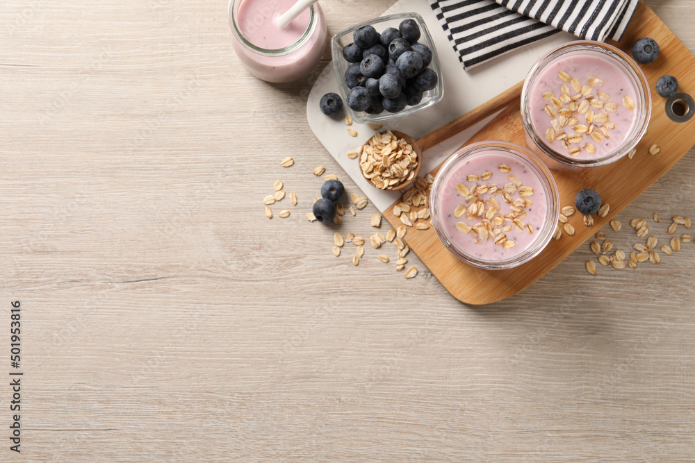Glasses of tasty blueberry smoothie with oatmeal on wooden table, flat lay. Space for text Glasses of tasty blueberry smoothie with oatmeal on wooden table, flat lay. Space for text