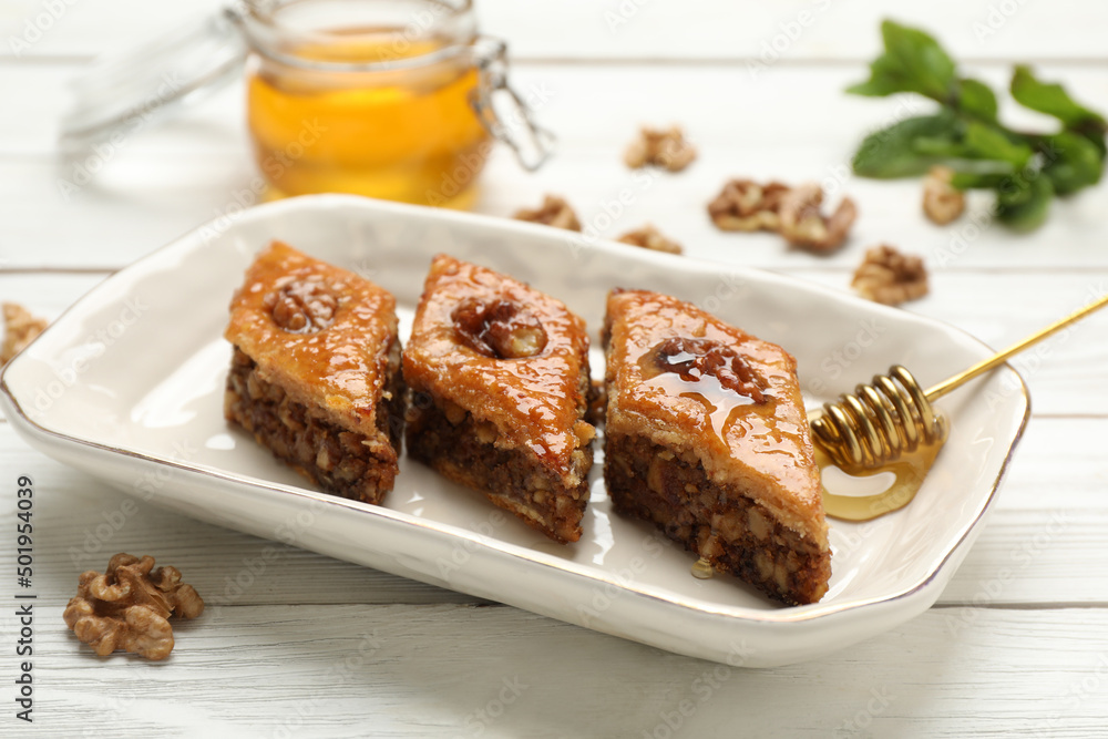 Delicious sweet baklava with walnuts on white wooden table