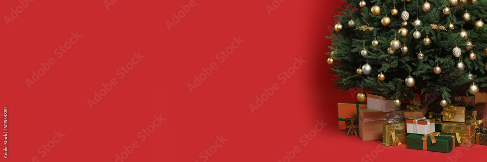 Beautifully decorated Christmas tree and gift boxes on red background, space for text. Banner design