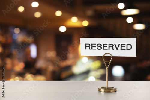Sign Reserved on white table in restaurant, space for text