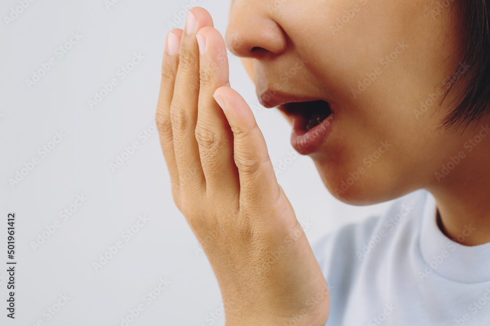 Asian woman checking her breath with hand test. Health Care concept. Asian woman checking her breath with hand test. Health Care concept.