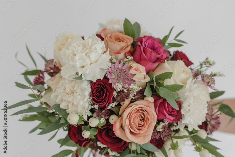 Wedding bouquet in bright colors. Red rose, cappuccino rose, eucalyptus, dianthus