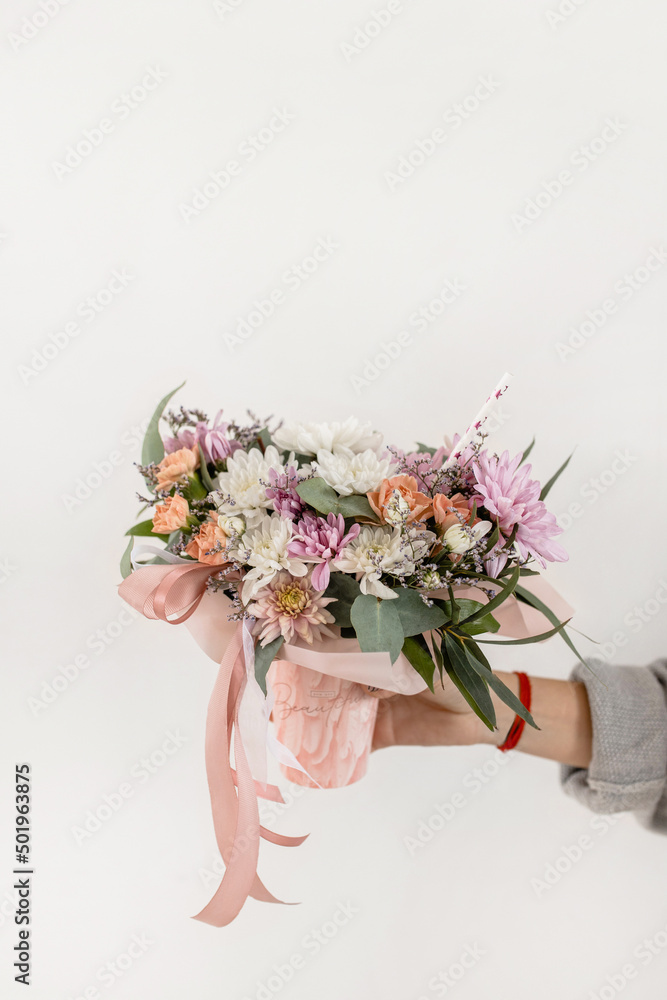 Fototapeta premium Flower arrangement in a glass with a straw on a white background. flower lemonade