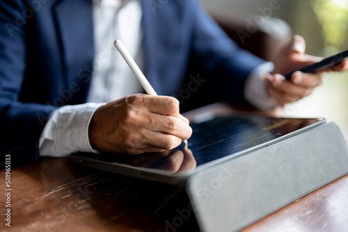 Close up of man hand using pen and laptop note something concept trading, planning or leaning.