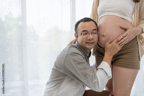 Close up of Asian Husband Listen to Baby Heart Sound in Belly of Pregnant Wife